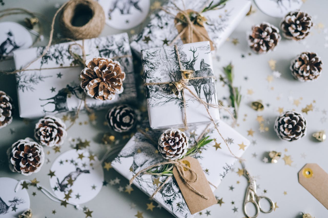 Beautifully wrapped Christmas gifts with pine cones and star confetti, capturing a festive holiday vibe.